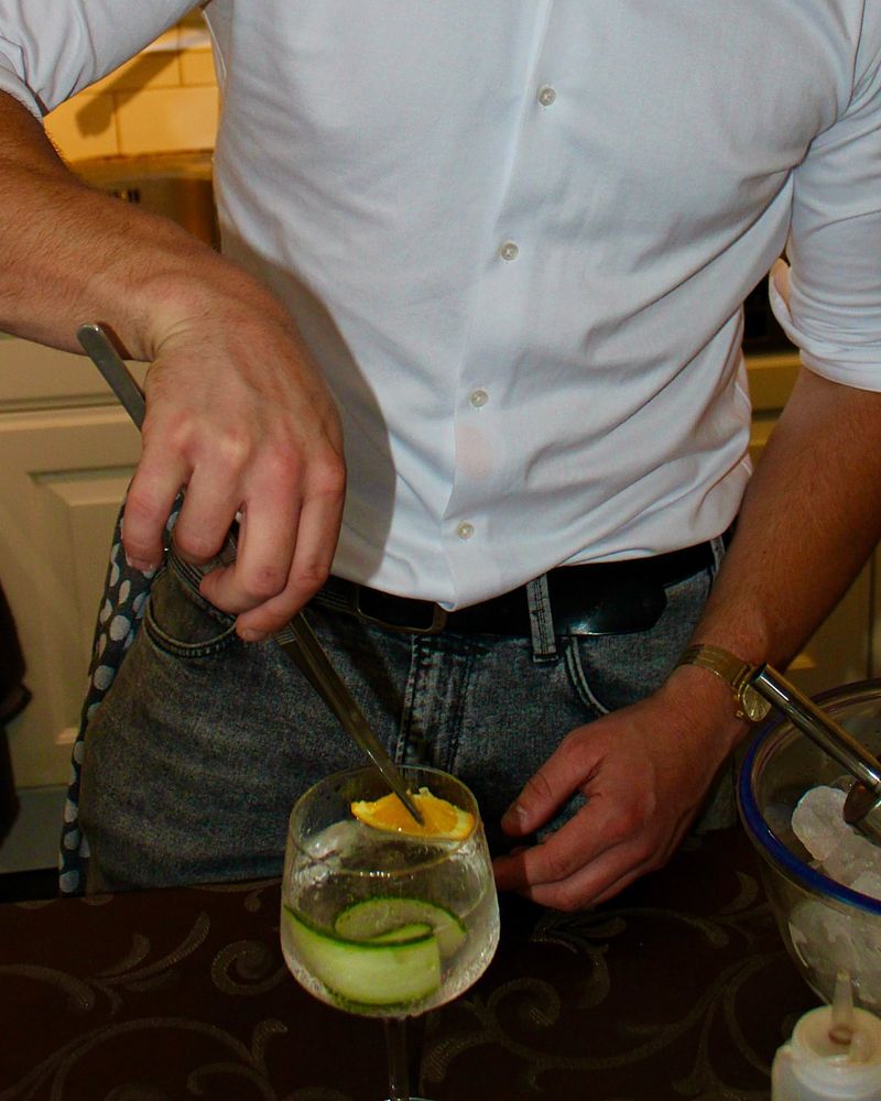 Rutger garneert een cocktail met een sinaasappelschijfje